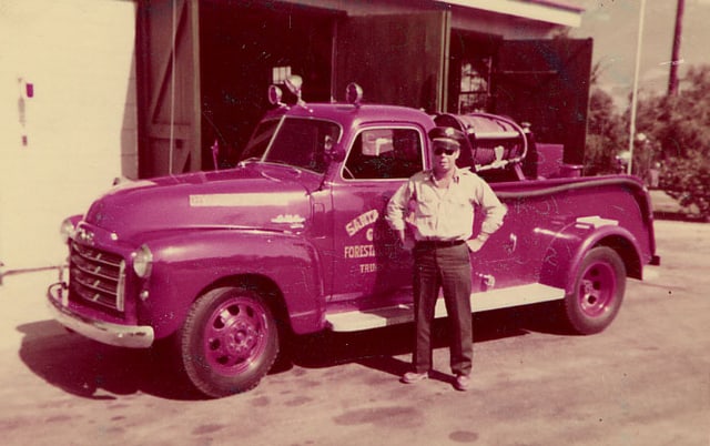 Forester Frank E. Dunne in front on old firetruck